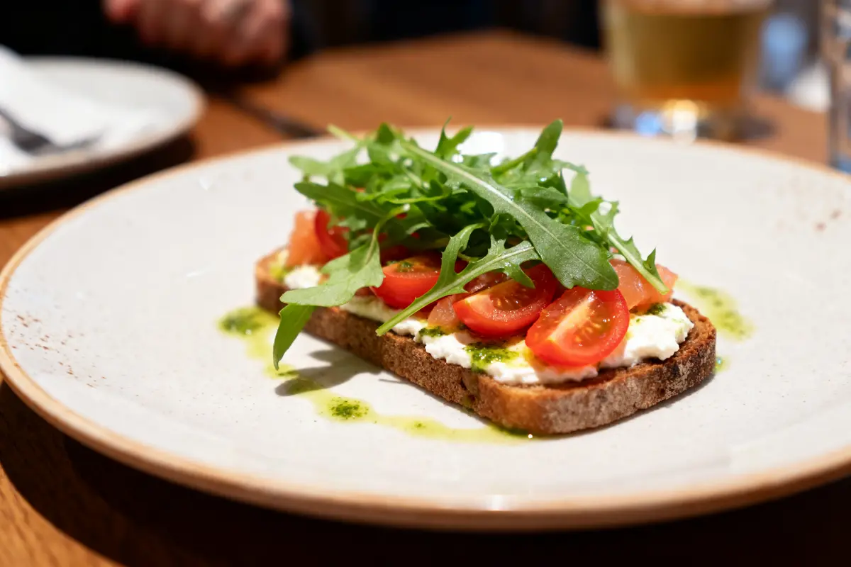Tartine de ricotta, tomates cerises et roquette, recette d'entrée froide gastronomique facile.
